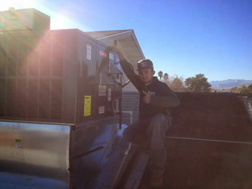 HVAC technician performing HVAC Inspection on a rooftop unit in Hamilton